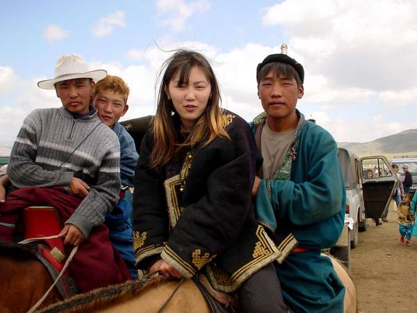 photo of Mongolia, in the fields outside Ulaan Baatar (Ulaanbaatar, Ulan Bator), cool Mongolian teenagers riding their horses on Nadam (Naadam), the Mongolian National holiday