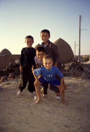 photo of Syria, around Aleppo, Syrian children in a village with beehive houses, bedouin mud homes