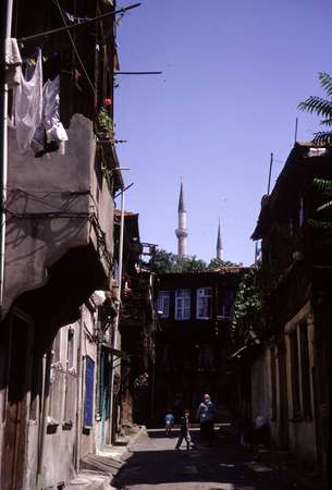 photo of Turkey, Istanbul, small street with wooden houses and minarets on the background